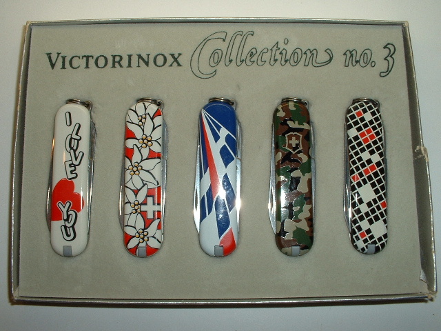 This is a special set of 58mm knives produced and sold as a set in this small thin cardboard box with a clear acetate slip cover. 2 of the knives were separately produced and for sale, the red edelweiss and the camouflage while the other 3 were only sold in this set so they are very hard to find.